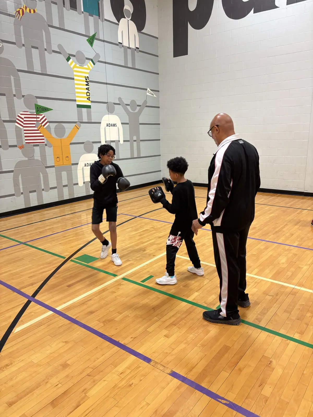 A coach working with a young boxer in the gym