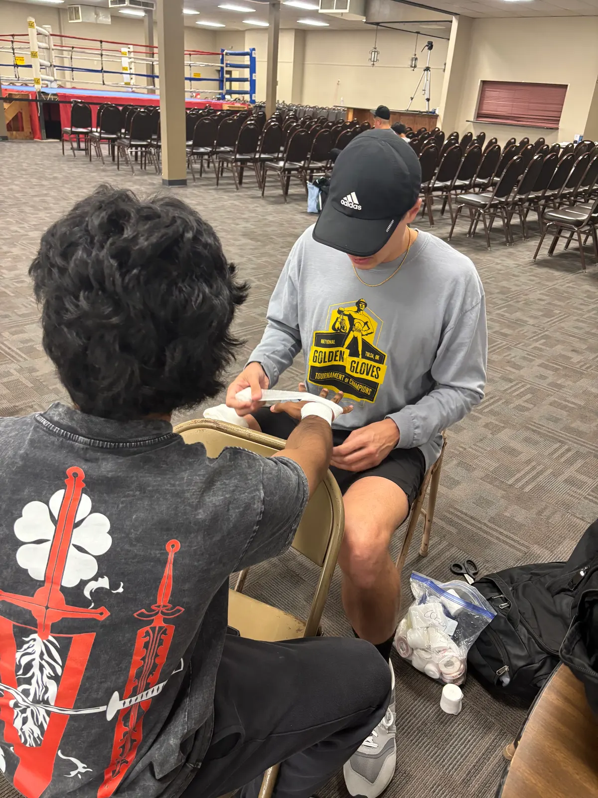 A coach wrapping a young boxer's hands