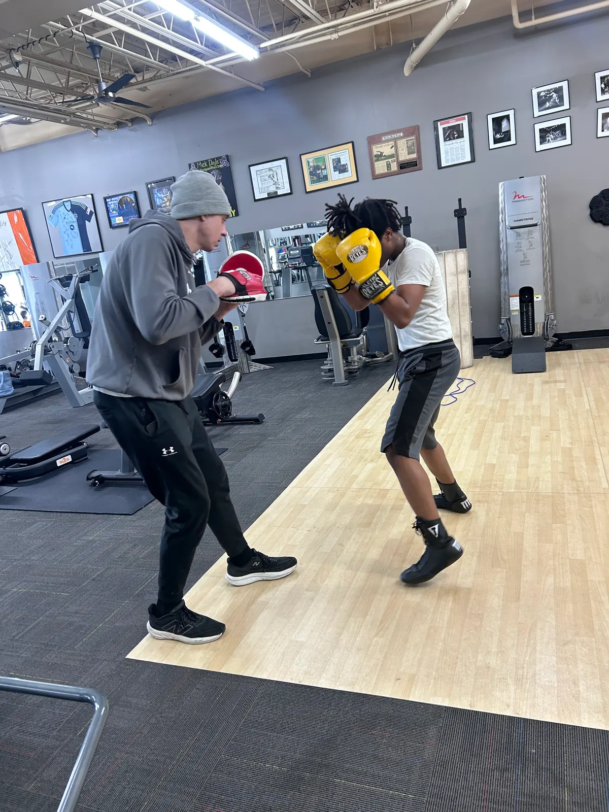 A coach holding mitts for a boxer